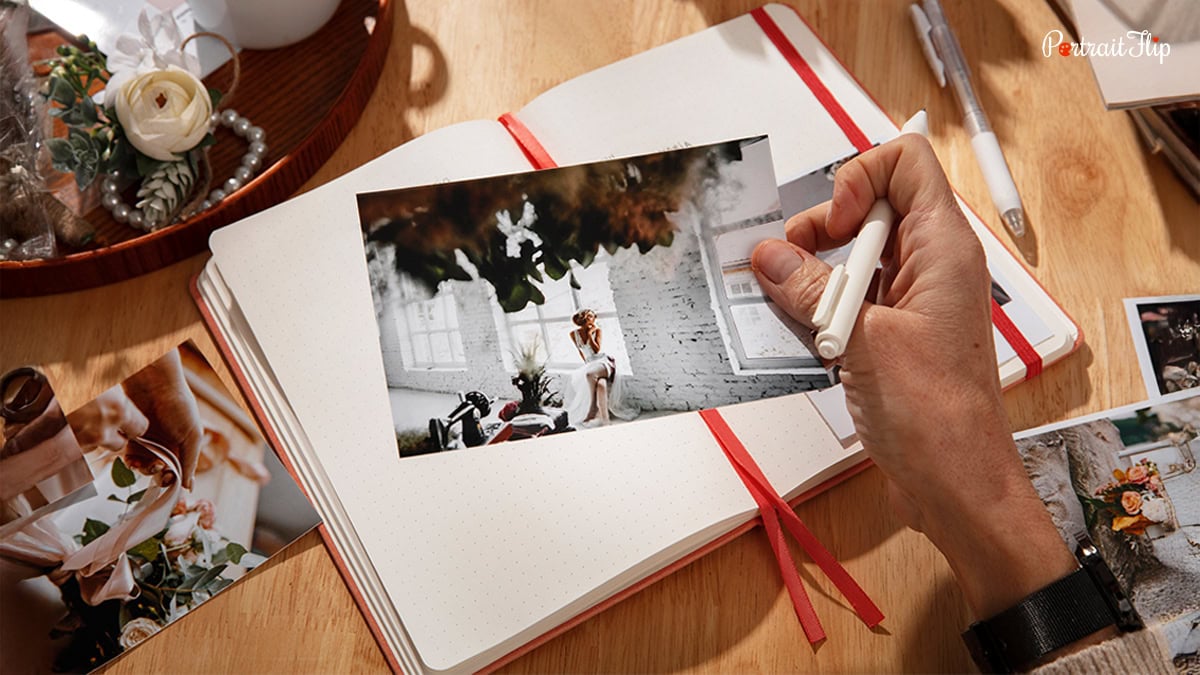 A photograph in a person's hand with a diary behind it.