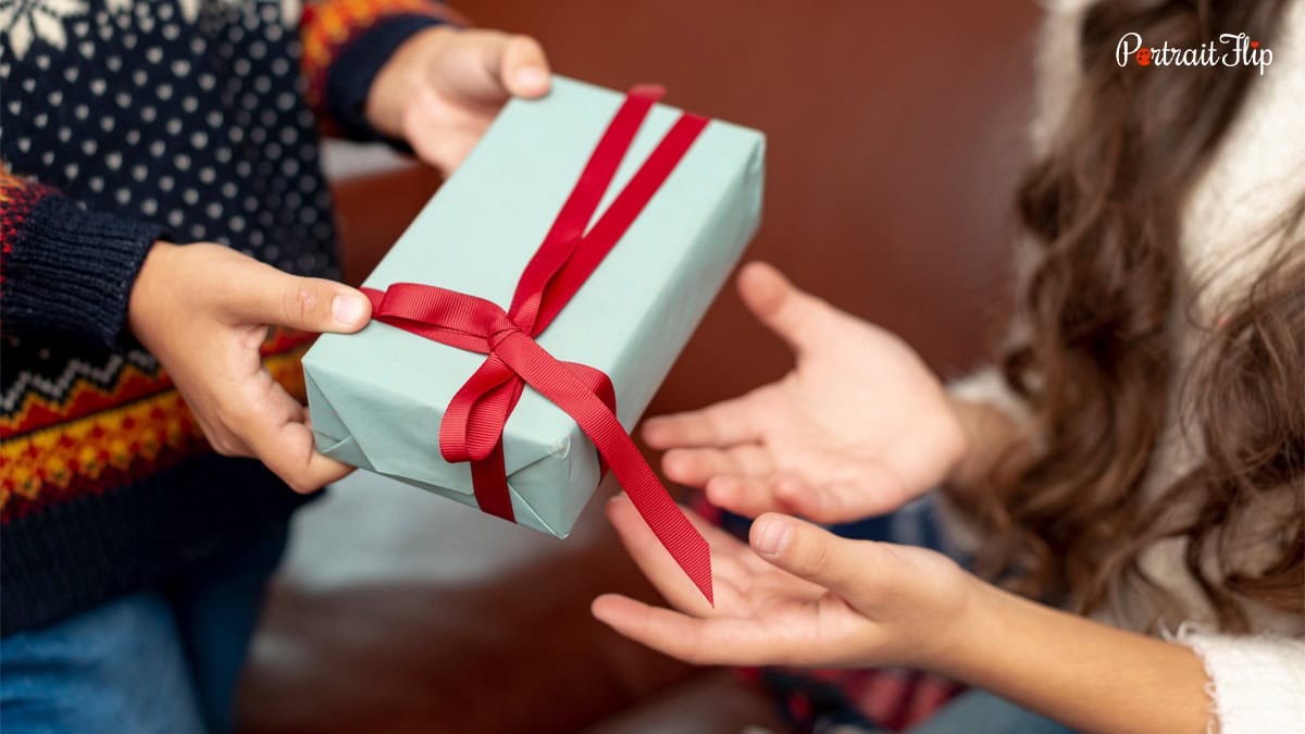 One person handing gift to another person