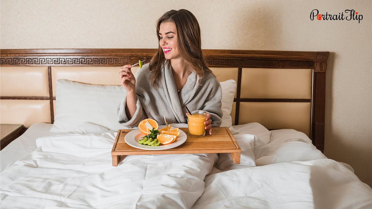 a woman enjoying her breakfast in bed