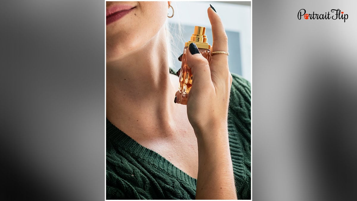 A woman spraying perfume on her neck