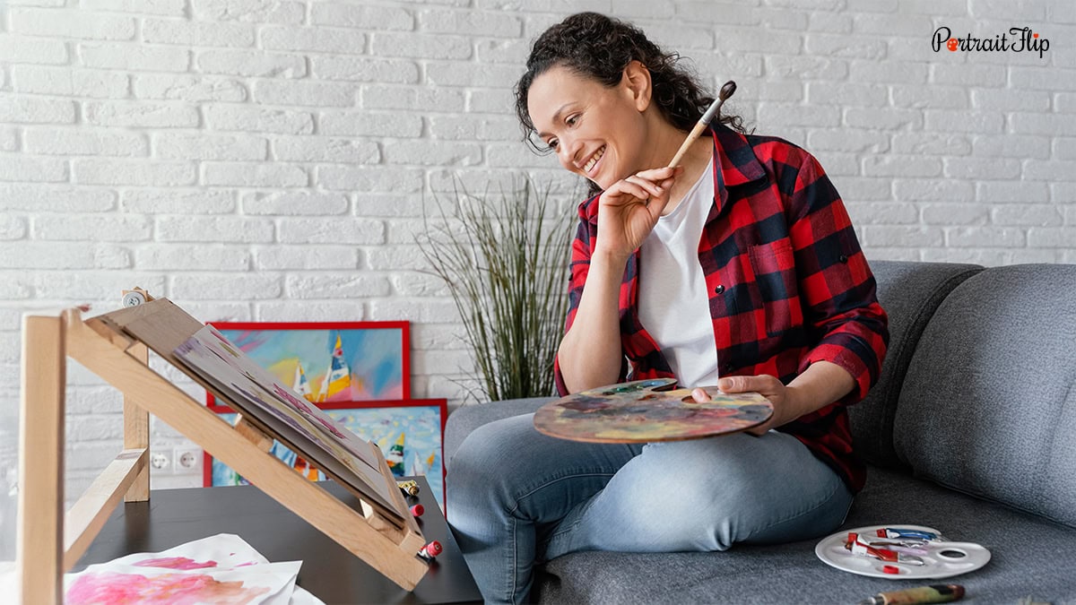 A woman painting a picture on canvas