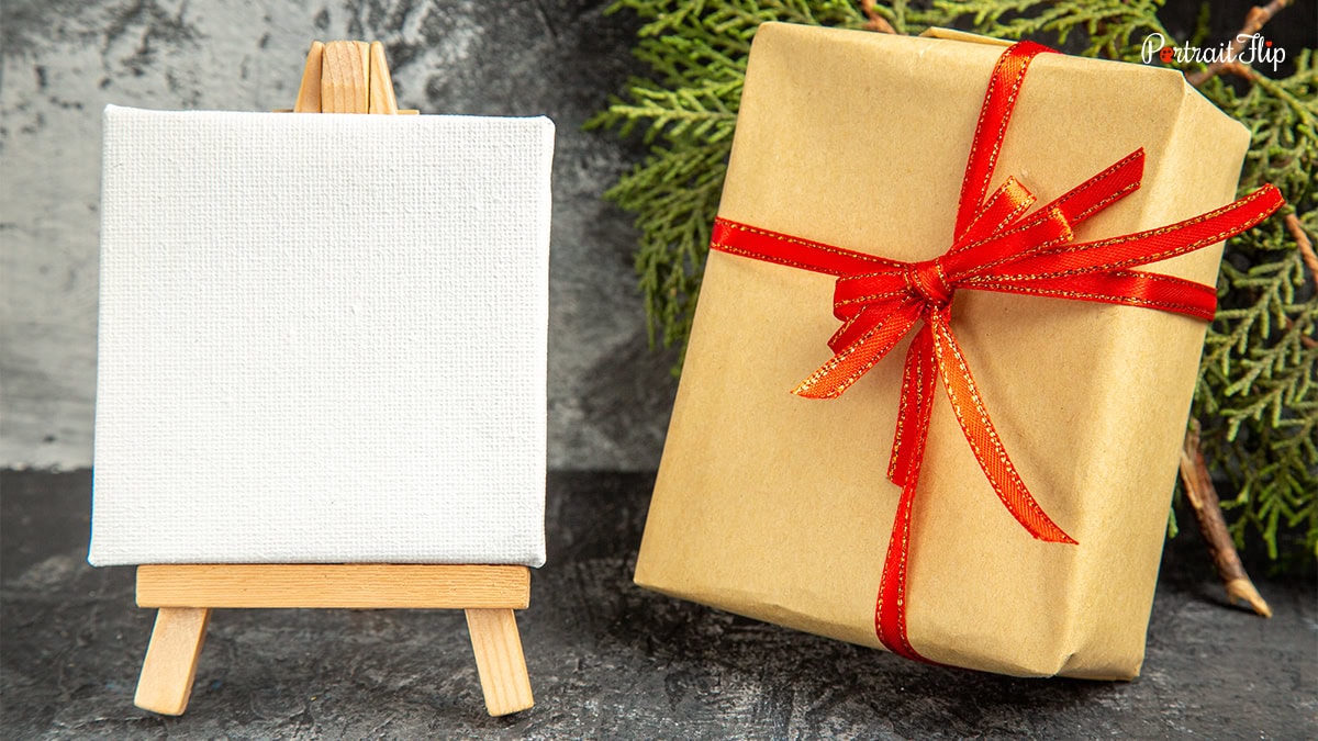 A canvas beside a gift wrapped