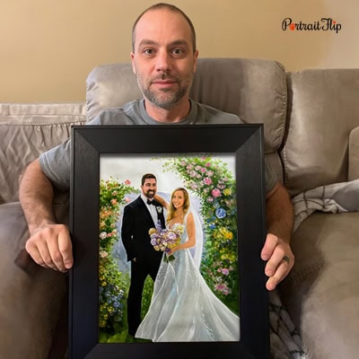 Man holding a framed custom impasto wedding couple portrait painting