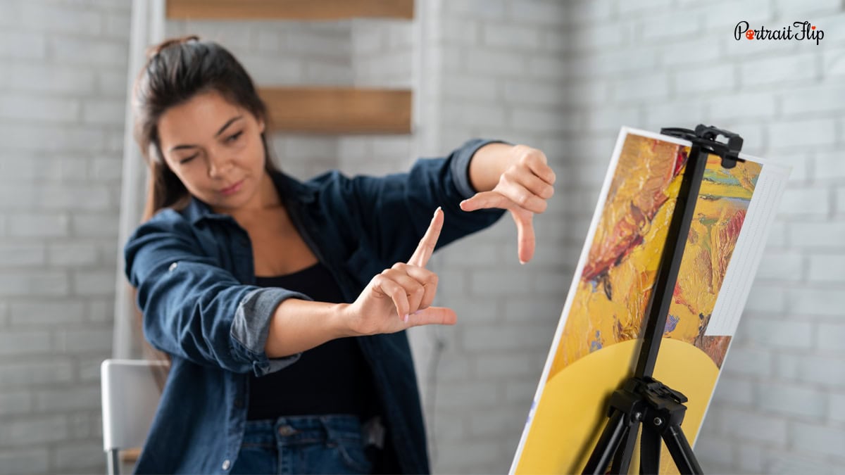 A woman examining the angle of a canvas