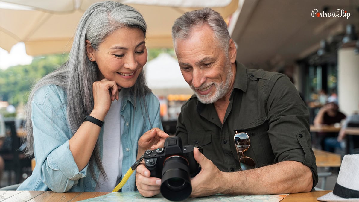 An old couple checking out camera